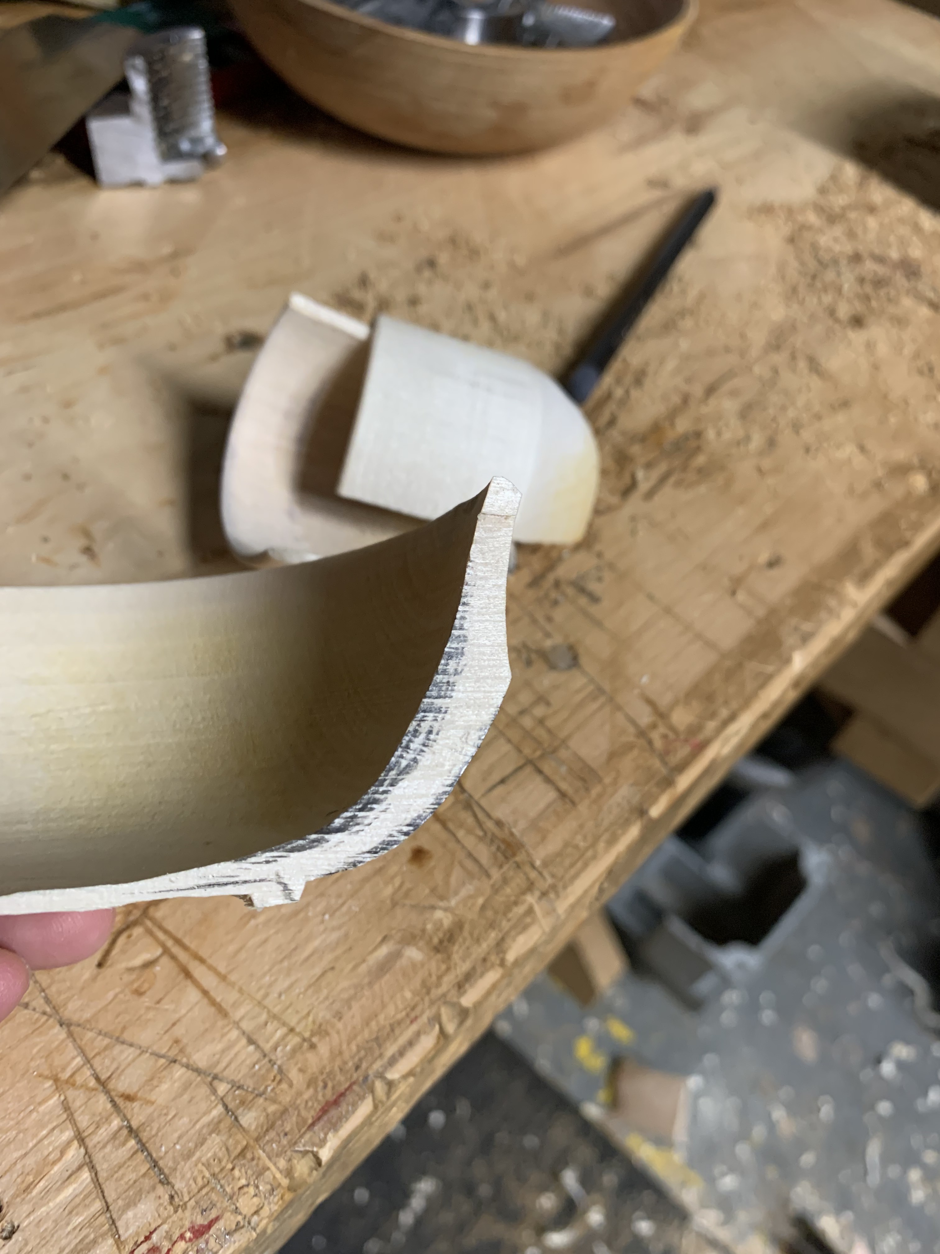 A bowl turned by Mary that's cut in half. The bowl is thin at the bottom and has pencil marks