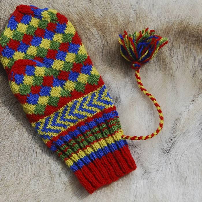 a colorful patterened mitten knitted with red, green, blue, and yellow yarn