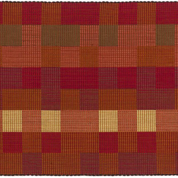 a geometric patterned rug with rich orange, red, green, and amber colors